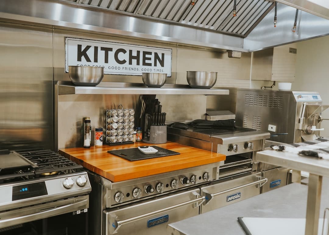 Commercial kitchen with stainless steel cooking equipment and ventilation hood