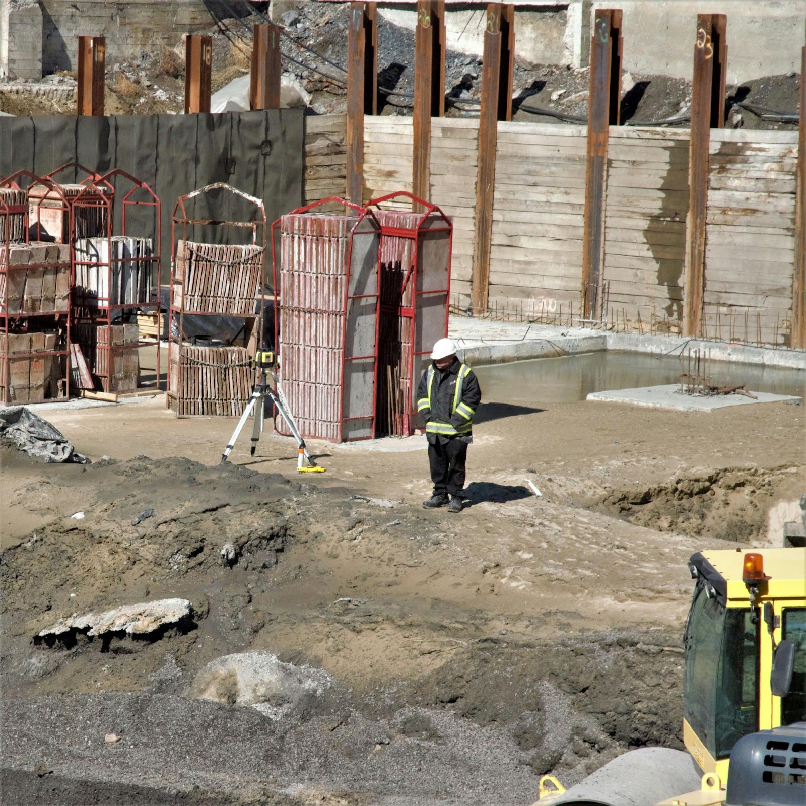 Surveyor on Construction Site With Tripod