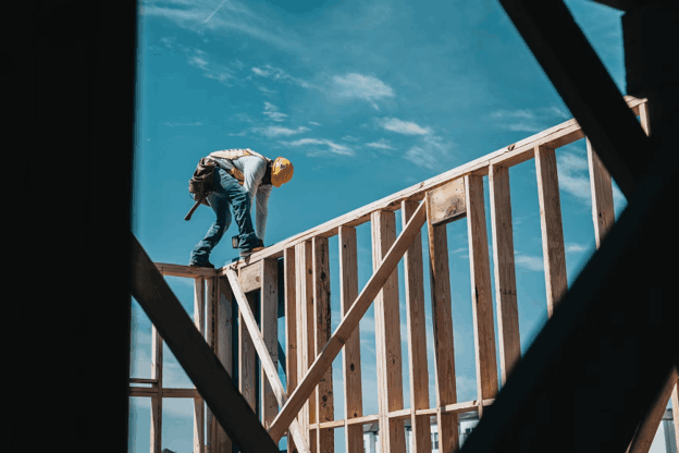 Contractor working on elevated framing inside a building
